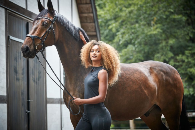 Caballo negro con una chica con ropa de equitación de House of montar